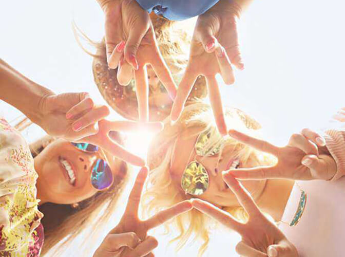 Grupo de meninas unidas, formando uma estrela com as mãos